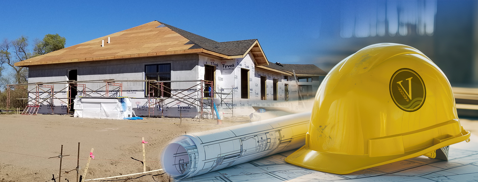 Building construction with hard hat and blue prints.